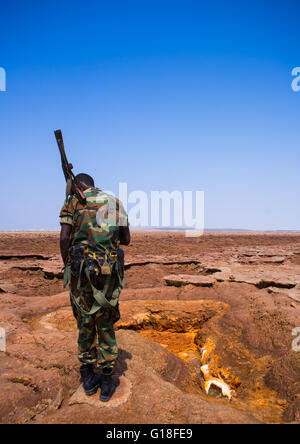 Un soldat éthiopien en face d'un lac acide dans la région Afar, dépression Danakil, Dallol, Ethiopie Banque D'Images