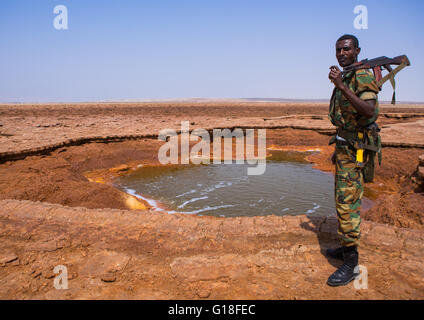 Un soldat éthiopien en face d'un lac acide dans la région Afar, dépression Danakil, Dallol, Ethiopie Banque D'Images