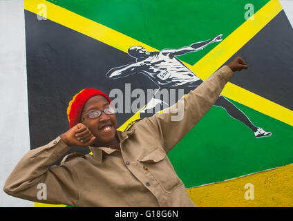 Rastafari fille appelée kizzy devant un drapeau de la Jamaïque avec hussein bolt murale, Oromo, Shashamane, Ethiopie Banque D'Images