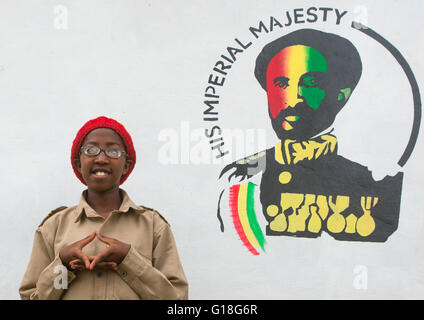 Rastafari fille appelée kizzy devant une peinture portrait Haile Selassie, Oromo, Shashamane, Ethiopie Banque D'Images