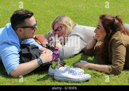 Glasgow, Royaume-Uni. Le 11 mai, 2016. Un grand nombre de travailleurs de bureau prenez le temps de vous détendre pendant leur pause déjeuner et prendre un peu de soleil dans le printemps chaud météo à hautes températures à George Square, Glasgow. L'image est de Greig Kennedy de Wemyss Bay, Mhairi Davidson de Lochgilphead et Imogen Jones d'Aberdeen de vous détendre sur les secteurs herbeux pendant leur pause déjeuner. Credit : Findlay/Alamy Live News Banque D'Images