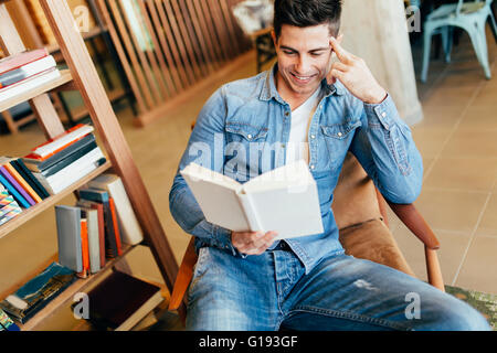 Bel homme l'étude par la lecture de livres et la préparation pour l'examen Banque D'Images