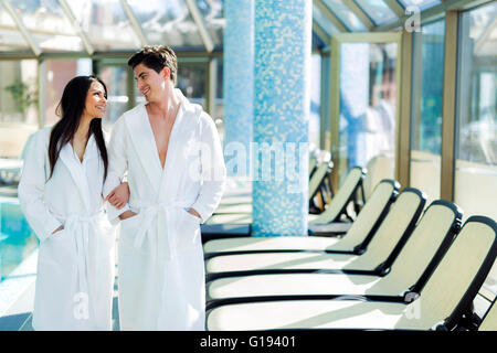 Couple in love debout à côté d'une piscine dans une robe et relaxant Banque D'Images