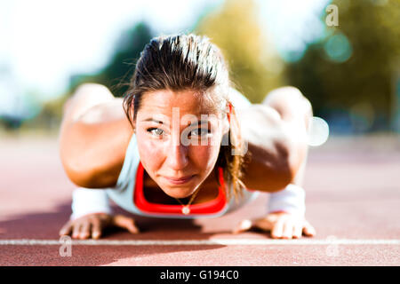 L'accent young Beautiful woman faisant push-ups à l'extérieur sur une chaude journée d'été Banque D'Images