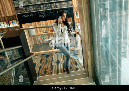 Businesswoman using phone intérieur et smiling Banque D'Images