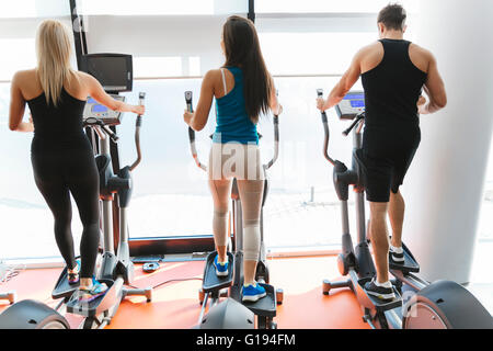 Personnes exerçant dans la salle de sport pour garder le corps en forme Banque D'Images