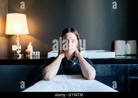 Portrait masseur avec les coudes sur la table de massage Banque D'Images