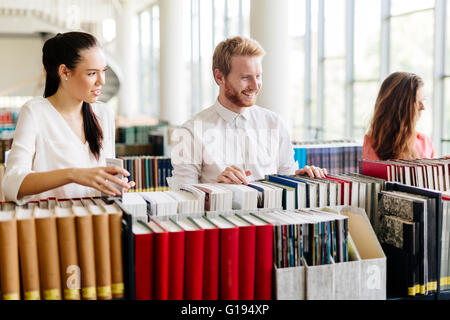 Groupe d'étudiants qui étudient en bibliothèque et la lecture de livres Banque D'Images