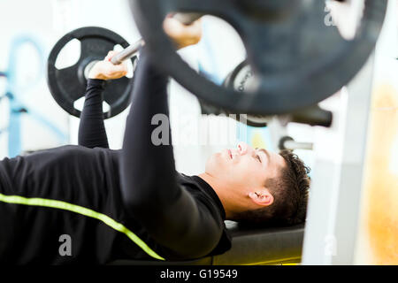 Gros plan du jeune beau mâle faisant des exercices sur un banc Banque D'Images