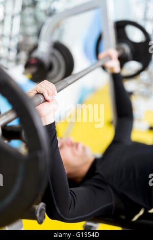 Gros plan du jeune beau mâle faisant des exercices sur un banc Banque D'Images
