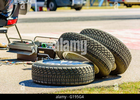 Emmaboda, Suède - mai 7, 2016 : 41ème Rallye de Suède du Sud dans le centre de services. Pile de pneus sur le tarmac avec boîte à outils dans le backg Banque D'Images