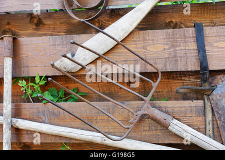 Vieux outils de jardin sur une clôture en bois Banque D'Images