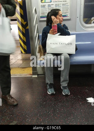 Un Lord & Taylor shopper avec son achat dans le métro à New York le 21 avril 2016. (© Richard B. Levine) Banque D'Images