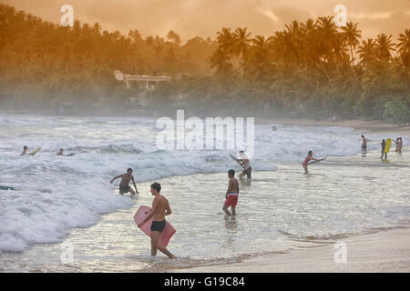 Sri Lankais à nager à l'extrémité ouest de cette station à la mode et de la plage, dévastée par le tsunami de 2004, Unawatuna, Galle, Sri Lanka Banque D'Images