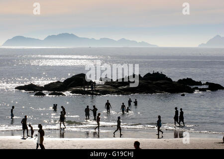 Les promeneurs sur la plage de la plage de Samil galicienne au coucher du soleil l'Île Cies en arrière-plan l'Espagne Banque D'Images