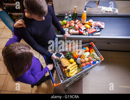 Jeune couple avant de commander au supermarché Banque D'Images