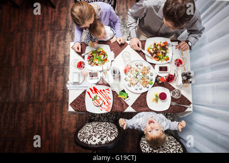 Famille de quatre personnes ayant délicieux repas dans un restaurant Banque D'Images