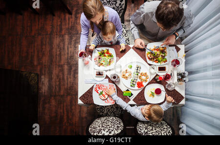 Famille de quatre personnes ayant délicieux repas dans un restaurant Banque D'Images