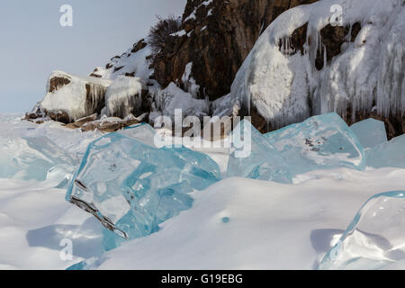 Glaçons transparent dans la neige sur un fond de roches glacées. Banque D'Images