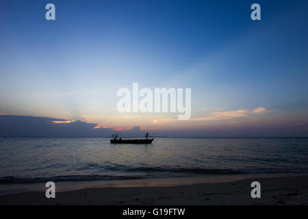 Tirez les pêcheurs dans leurs courriers du soir dans les bateaux traditionnels dans la baie à Stone Town, Zanzibar, Tanzanie Banque D'Images