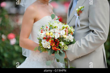Bride holding bouquet de fleur de mariage de roses blanches Banque D'Images