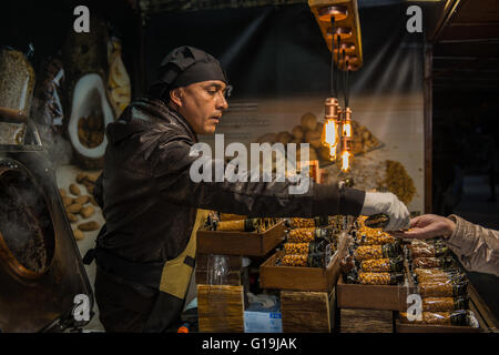 Portrait d'un homme cuisiner un peu de caramel, d'amande, sur un stand de rue. Banque D'Images