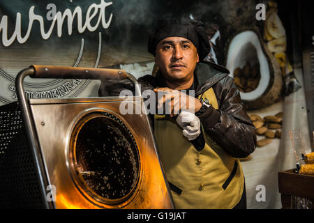 Portrait d'un homme cuisiner un peu de caramel, d'amande, sur un stand de rue. Banque D'Images