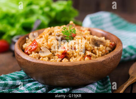 Le boulgour avec le poulet, les champignons et les tomates dans un bol en bois. Vue d'en haut Banque D'Images