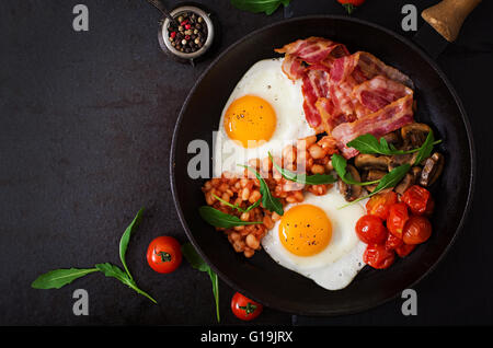 Petit-déjeuner anglais - œuf frit, haricots, tomates, champignons, du bacon et des toasts. Vue d'en haut Banque D'Images