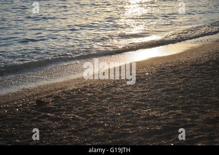 Les vagues du soir sur la plage avec la mer scintillante. Sukosan, Croatie Banque D'Images