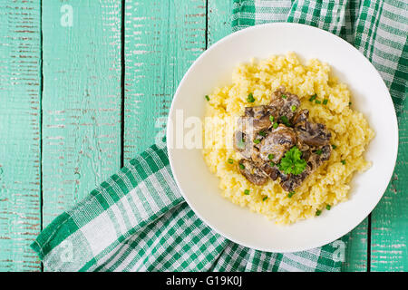 Porridge de millet aux champignons dans un bol blanc. Vue d'en haut Banque D'Images