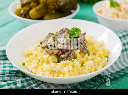 Porridge de millet aux champignons dans un bol blanc Banque D'Images