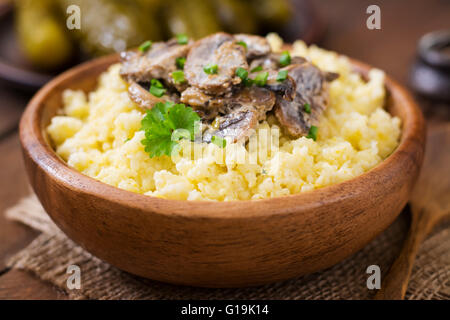 Porridge de millet aux champignons dans un bol en bois Banque D'Images