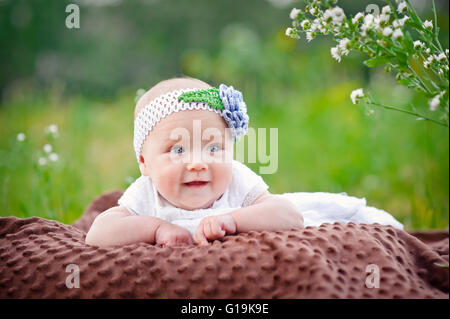 Charmante enfant. Little girl with hat allongé sur son ventre et su Banque D'Images