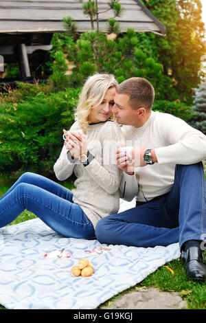 Couple heureux de boire le thé dans un parc d'automne Banque D'Images