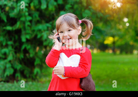 Enfant parle au téléphone dans le parc Banque D'Images