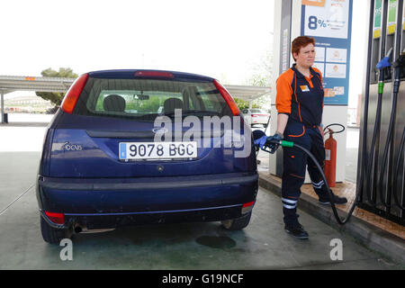 Femme pompiste, remplissage Ford Focus voiture à la station d'essence Repsol.Espagne. Banque D'Images