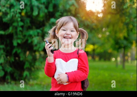 Happy girl parler au téléphone dans le parc Banque D'Images