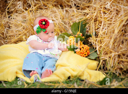 Baby girl sur le foin dans le style ukrainien Banque D'Images