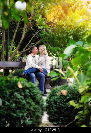 Couple d'amoureux sur un banc de parc d'automne Banque D'Images