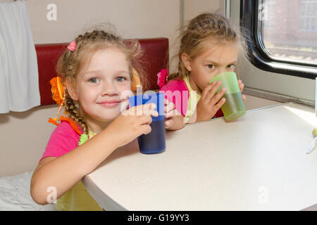 Deux petites sœurs dans un train de boire du thé à une table sur la place inférieure dans le compartiment de deuxième classe wagon Banque D'Images