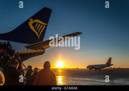 Les passagers à bord d'un vol Ryanair au lever du soleil dans l'aéroport de Bristol, Angleterre, Royaume-Uni Banque D'Images