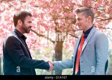 Deux businessmen shaking hands outdoors Banque D'Images