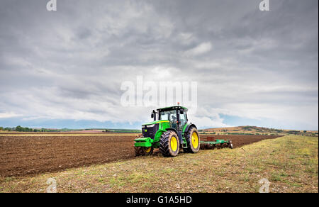 Karlovo, Bulgarie - Août 22th, 2015 : labourer un champ avec John Deere 6930 tracteur. John Deere 8100 a été fabriqué en 1995- Banque D'Images