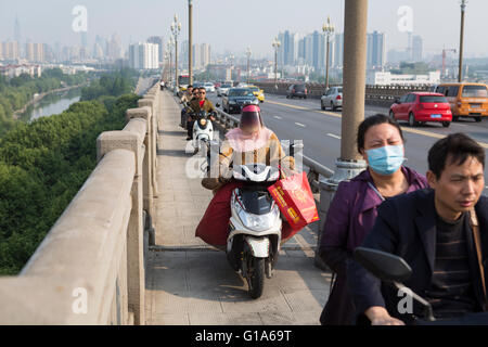 Les chinois en passant le pont de la rivière Yangtze occupé sur les cyclomoteurs et scooters à Nanjing, Chine Banque D'Images