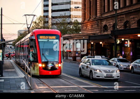 Un tram dans une rue à côté d'un taxi à Adélaïde, Australie Banque D'Images