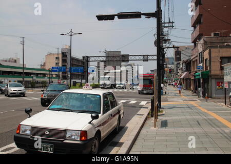 Couleur blanc Japon traditionnel arrêt de taxi par à la rue animée à Kyoto, d'attente pour les passagers. Banque D'Images