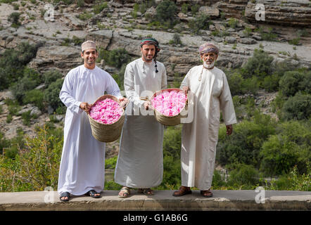 Les hommes en costume traditionnel omanais montrant outre de panier plein de pétales de rose Banque D'Images