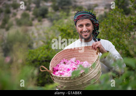 Les hommes en costume traditionnel omanais montrant outre de panier plein de pétales de rose Banque D'Images