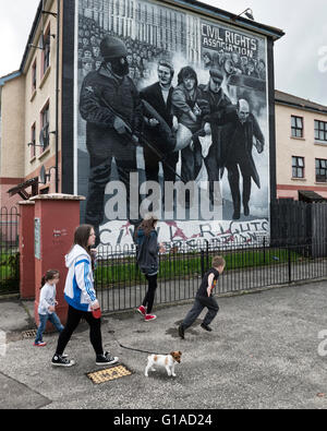 Les enfants catholiques locales passant les droits civils dimanche sanglant murale. Derry Londonderry. L'Irlande du Nord. UK. L'Europe Banque D'Images